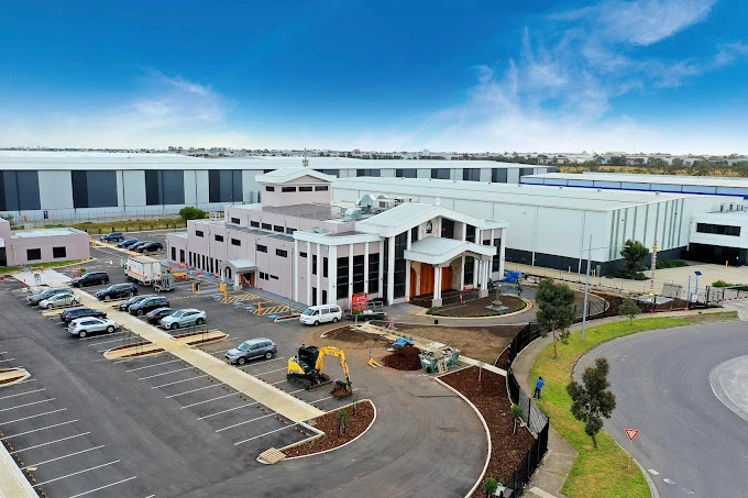Commercial building frontage with glazed entries and street planting.