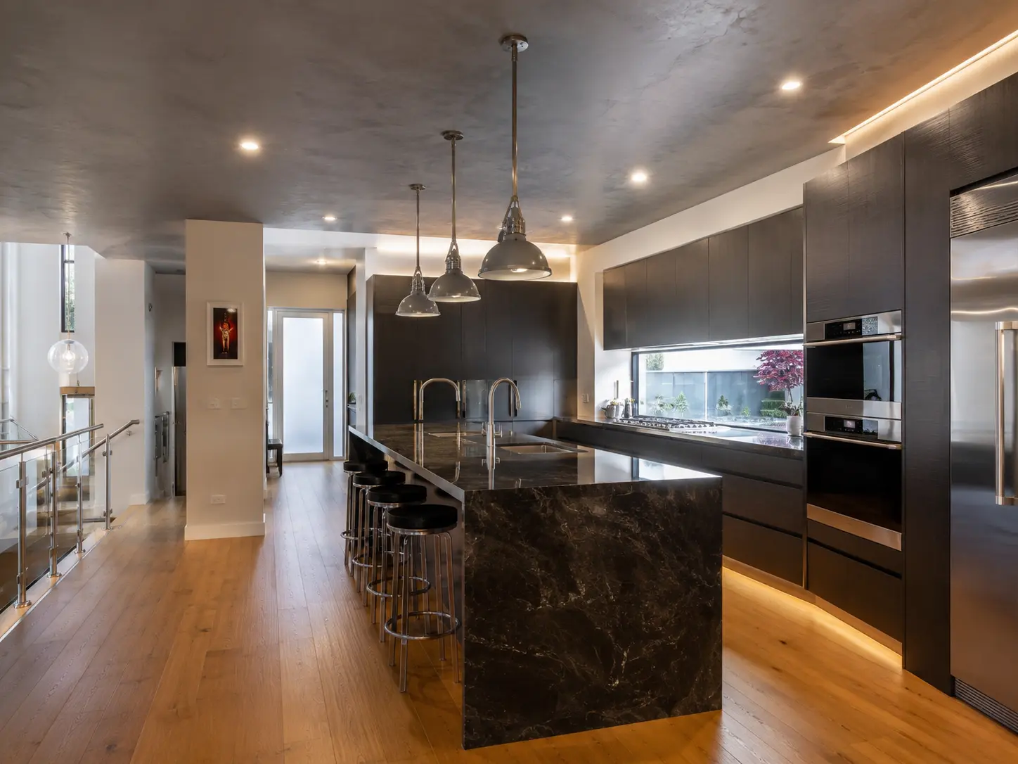 Open-plan kitchen and living area featuring stone benchtops, integrated joinery and refined interior detailing.